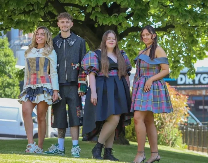 Four fashion students wearing tartan-inspired outfits outdoors at Drygate, Glasgow. Four fashion students wearing tartan-inspired outfits outdoors at Drygate, Glasgow.